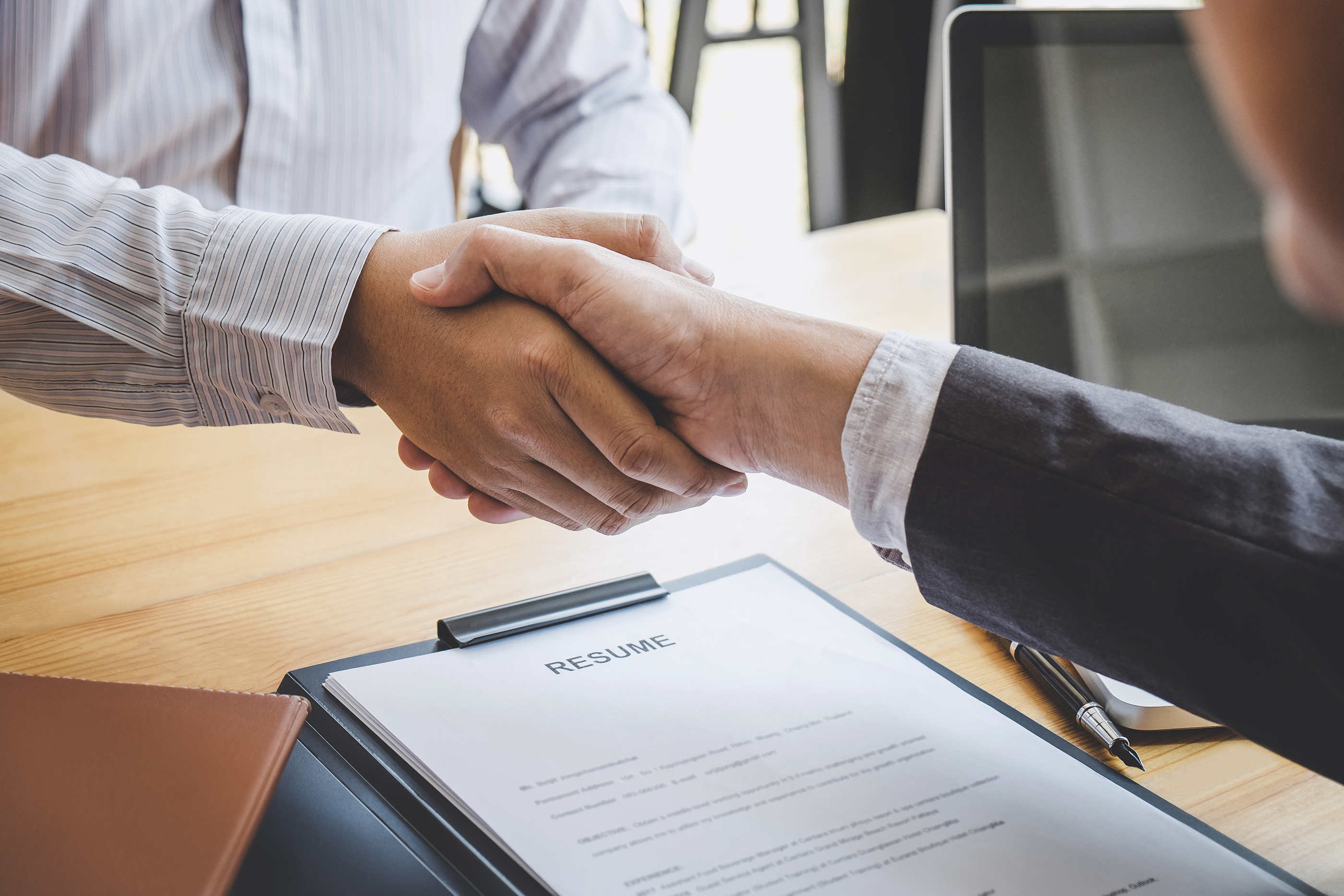 Conceptual image of a handshake, symbolizing first impressions and multi-dimensional evaluation during a consultant interview.