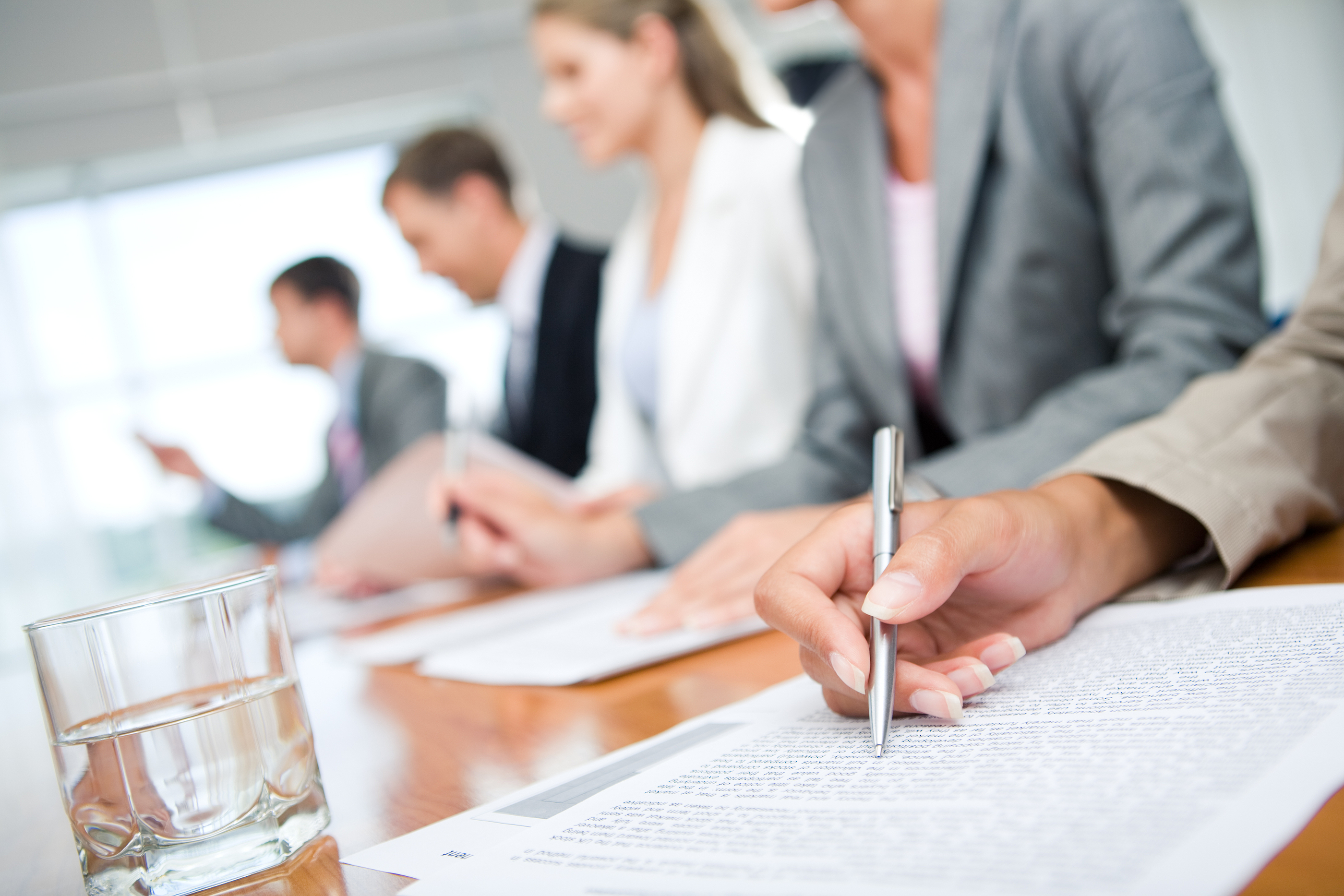 Candidate answering questions while a consultant interview panel observes and takes notes.