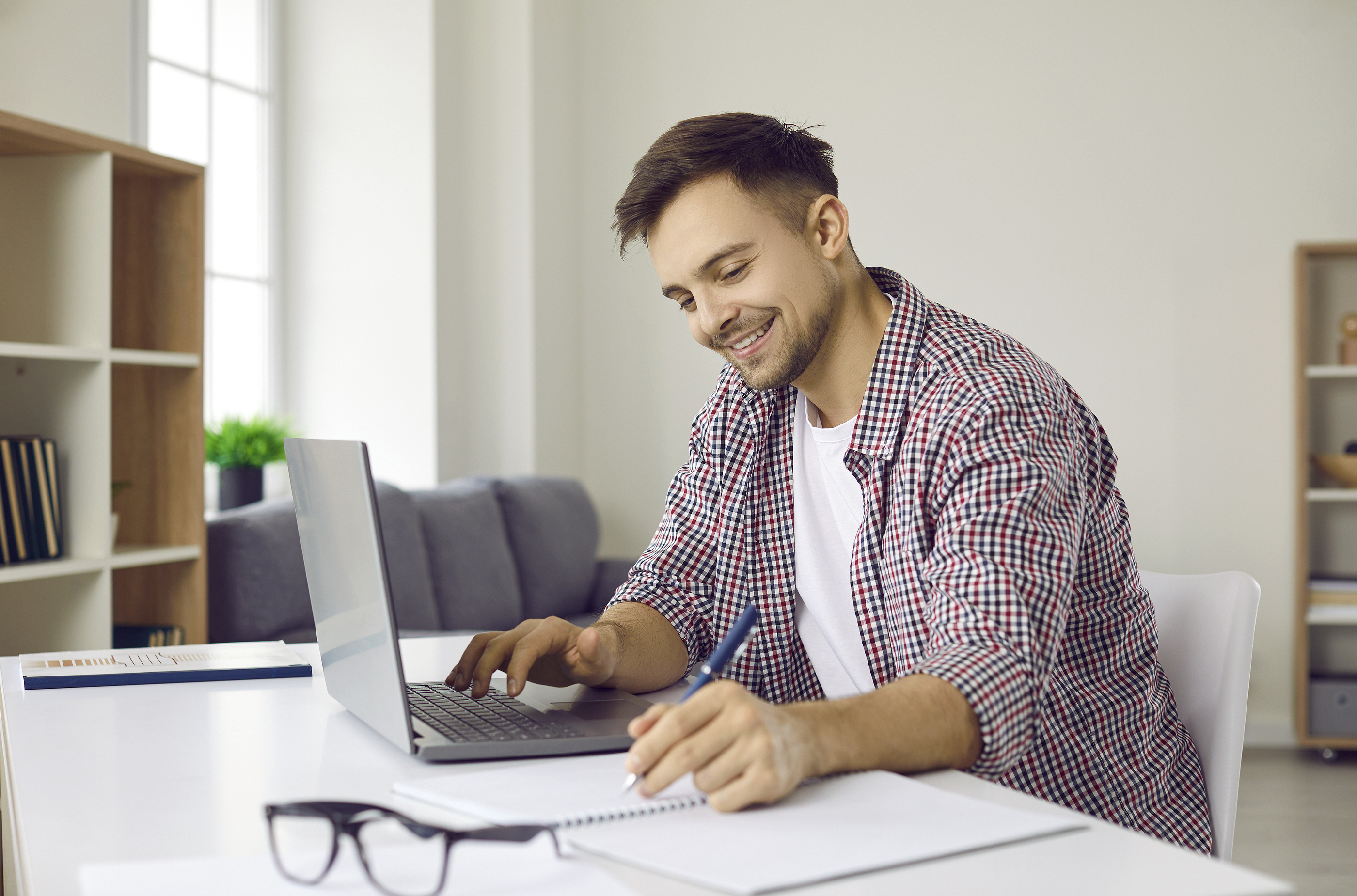 Image of a person smiling while using a laptop, representing structured consultant interview preparation with the 8P Framework.