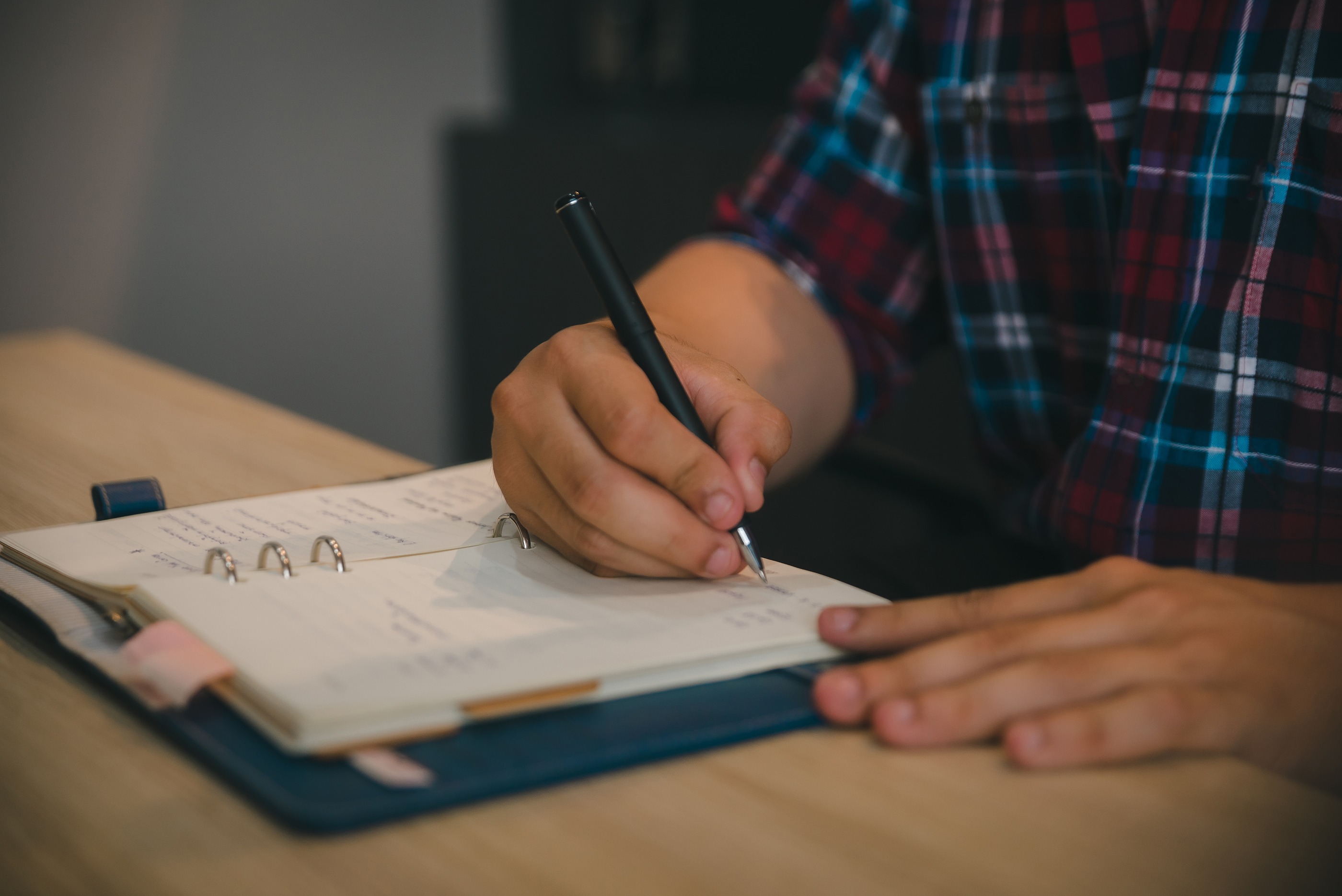 Candidate writing a preparation schedule in a planner, using the 8P Framework to organize consultant interview preparation.
